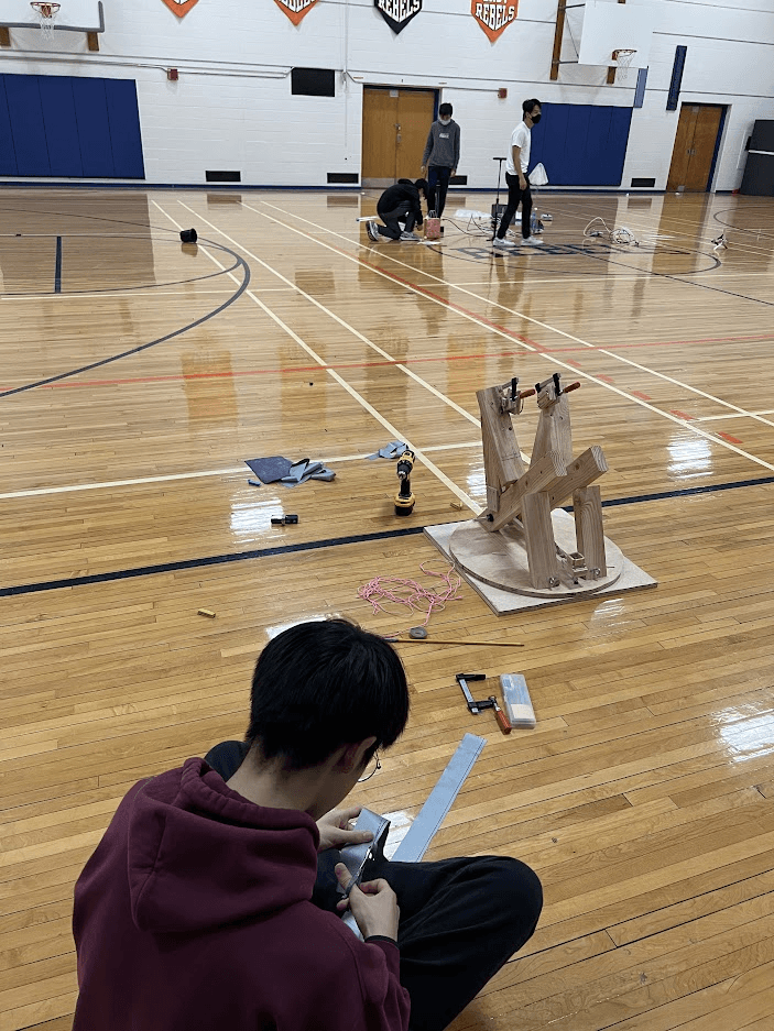 A member kneeling beside a device during a gym test run