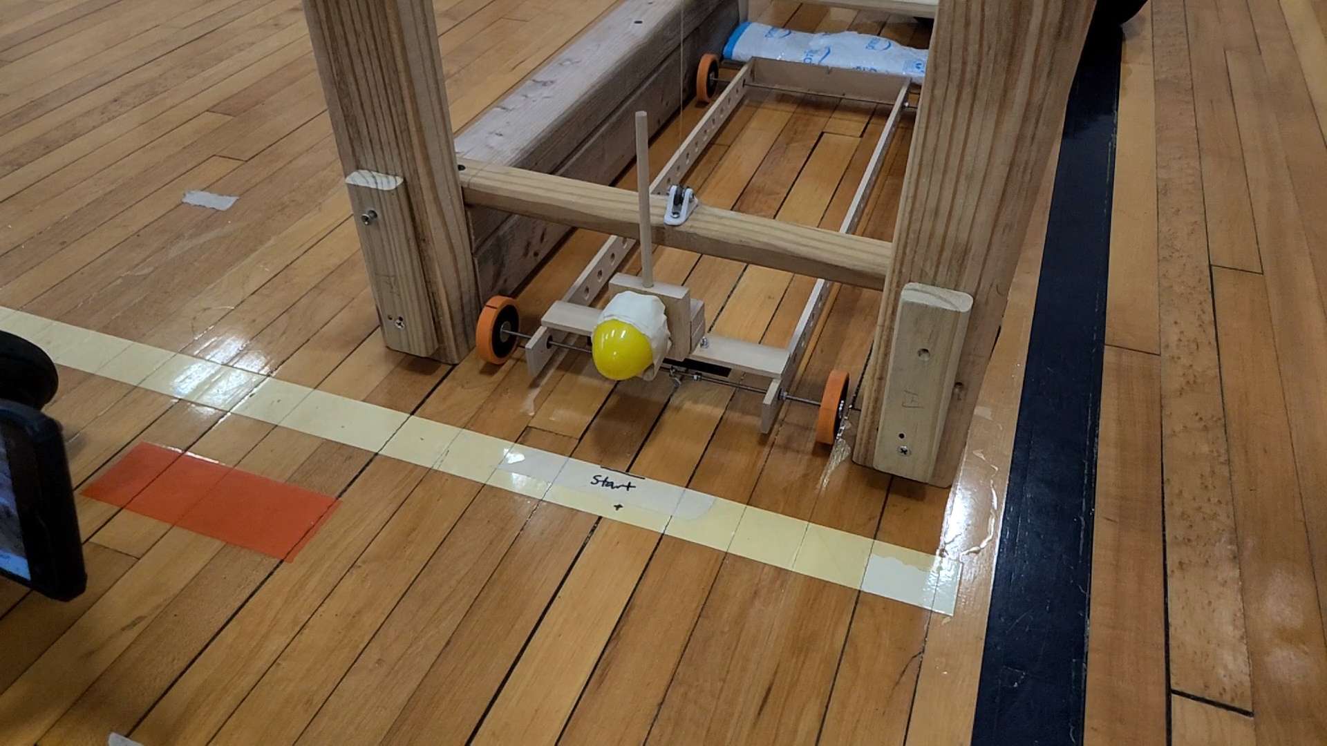 A wooden build event device on a gym floor, ready for its run