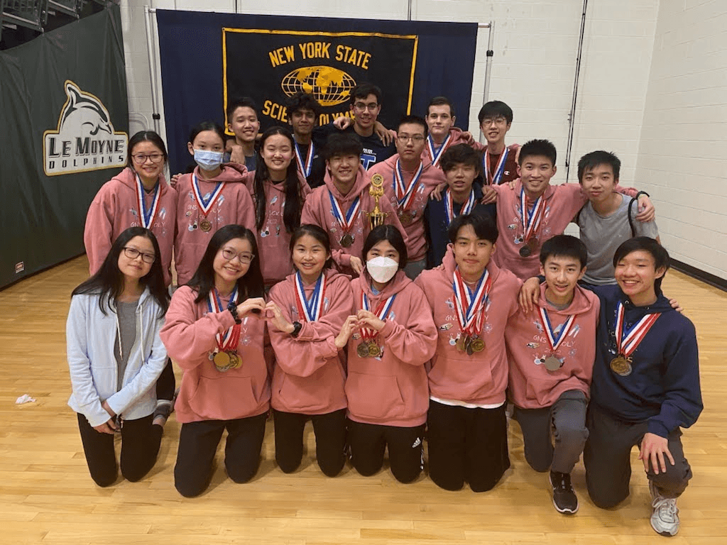 The team in pink hoodies and medals gathered at Le Moyne College for the state tournament