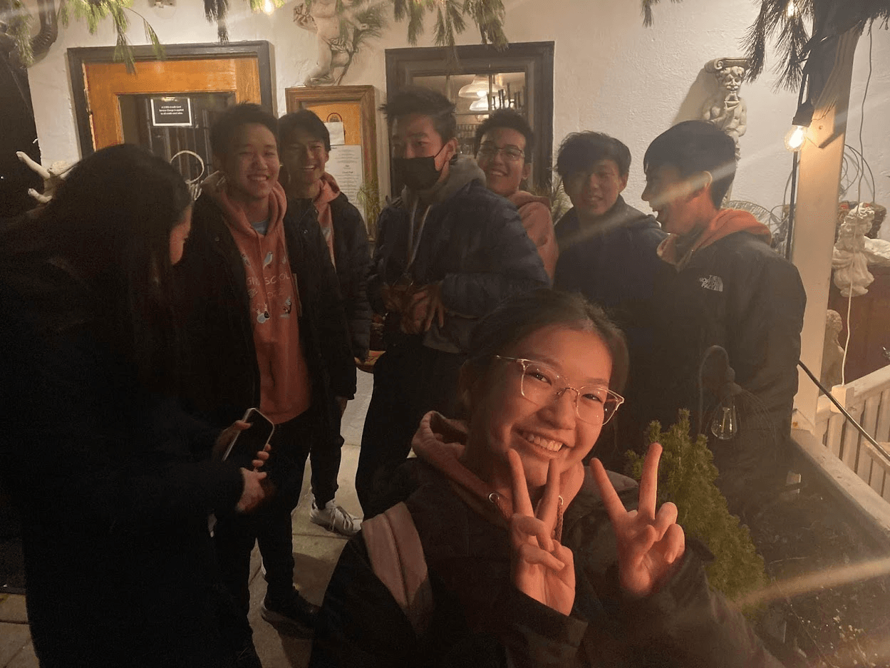 Members smiling outdoors at night on a competition trip